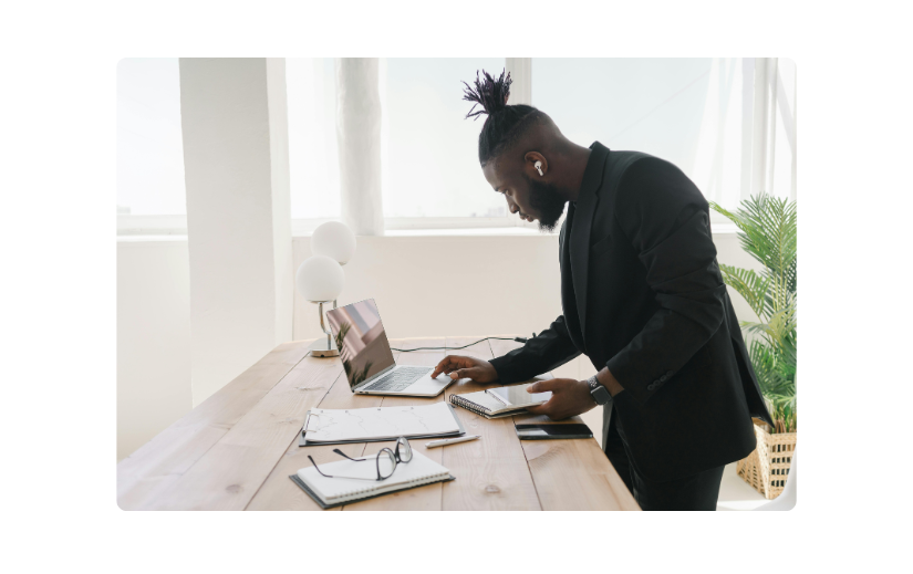 Professional man in a suit working on a laptop with notes, representing high-paying side gigs for busy entrepreneurs.